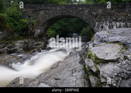 Rauschende Wildwasserstromschnellen der Falls of Dochart in der Stadt Killin, Perthshire, im zentralen schottischen Hochland. Stockfoto