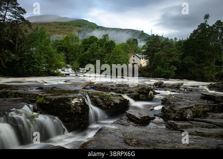 Rauschende Wildwasserstromschnellen der Falls of Dochart in der Stadt Killin, Perthshire, im zentralen schottischen Hochland. Stockfoto