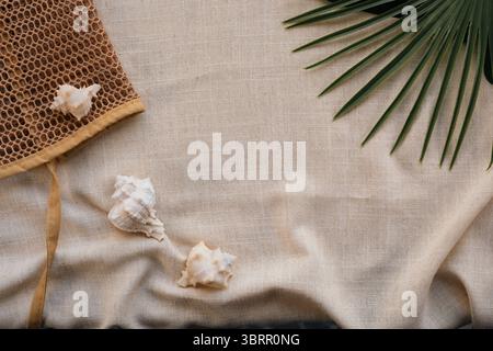 Flache Strandthemen mit Muscheln, Strandtasche und tropischen Blättern, leerer Platz für Text Stockfoto