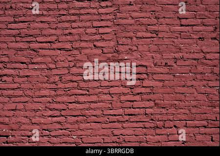 Einheitliche rote Backsteinwand mit strukturiertem Hintergrund, geeignet für verschiedene Design- und Präsentationsanforderungen Stockfoto