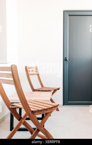 Holzstühle und Couchtisch auf dem Balkon des Apartments, selektiver Fokus Stockfoto