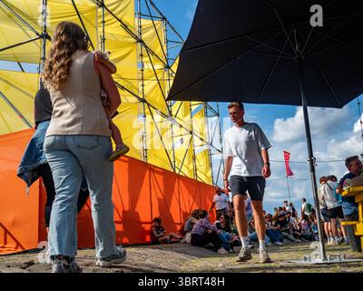 Nijmegen, Niederlande. Juli 2025. Man sieht Menschen hinter einer der Bühnen laufen. Diese Veranstaltung findet gleichzeitig mit den Internationalen vier-Tage-Märschen statt. Jedes Jahr präsentiert diese Veranstaltung ein vielseitiges Programm mit mehr als 1.000 Acts auf über 45 Bühnen, die alle völlig kostenlos sind und über 1,5 Millionen Menschen in die Innenstadt von Nijmegen locken. Quelle: SOPA Images Limited/Alamy Live News Stockfoto