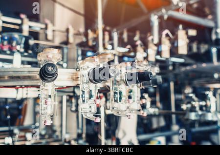 Gewindespanner befinden sich an den Schiebern der Maschinen. Industrieunternehmen zur Herstellung von Socken Stockfoto