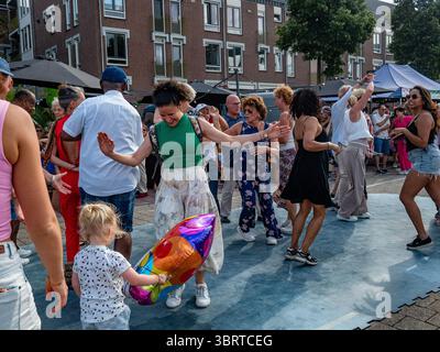 Nijmegen, Niederlande. Juli 2025. Man sieht Leute, die auf der Straße Salsa-Musik tanzen. Diese Veranstaltung findet gleichzeitig mit den Internationalen vier-Tage-Märschen statt. Jedes Jahr präsentiert diese Veranstaltung ein vielseitiges Programm mit mehr als 1.000 Acts auf über 45 Bühnen, die alle völlig kostenlos sind und über 1,5 Millionen Menschen in die Innenstadt von Nijmegen locken. (Foto: Ana Fernandez/SOPA Images/SIPA USA) Credit: SIPA USA/Alamy Live News Stockfoto