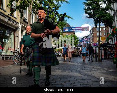 Nijmegen, Niederlande. Juli 2025. Ein Mann spielt Dudelsack, während er auf der Straße läuft. Diese Veranstaltung findet gleichzeitig mit den Internationalen vier-Tage-Märschen statt. Jedes Jahr präsentiert diese Veranstaltung ein vielseitiges Programm mit mehr als 1.000 Acts auf über 45 Bühnen, die alle völlig kostenlos sind und über 1,5 Millionen Menschen in die Innenstadt von Nijmegen locken. (Foto: Ana Fernandez/SOPA Images/SIPA USA) Credit: SIPA USA/Alamy Live News Stockfoto
