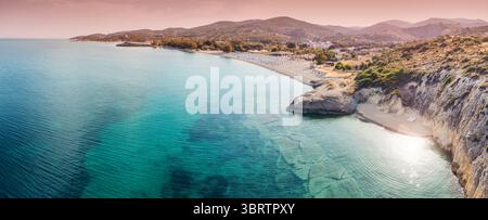 Atemberaubender Panoramablick auf kristallklares türkisfarbenes Wasser, das die Sandküste umschließt und im warmen Glanz der untergehenden Sonne getaucht ist Stockfoto