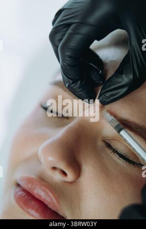 Nahaufnahme von professionellen Händen, die Botox in die Stirnleine einer Frau einnisten Stockfoto