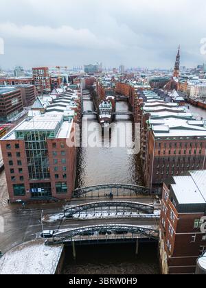 Aus der Vogelperspektive der Speicherstadt, die den gedämpften Himmel zwischen Backsteinhäusern reflektieren, ein historischer Kontrast unter einer Schneedecke, Hamburg, Deutschland. Stockfoto