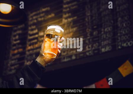 Feiern Sie nach der Arbeit mit einem kalten Pint Craft Beer in gemütlicher Bar Stockfoto