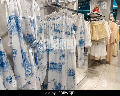 Kiew, Ukraine 12. Juli 2025 bezaubernde Einzelhandelsausstellung mit blau-weißer Kleidung mit Landschaftsmotiv, ideal für den Sommer. Stilvolle Kleidung hängt in einem Stockfoto