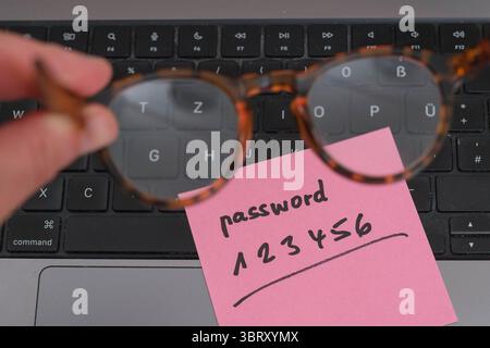 Sicherheitsrisiko auf dem Schreibtisch: Ein Zettel mit dem unsicheren Passwort 123456 liegt offen auf einem Laptop, ein klassisches Beispiel für fahrlässigen Umgang mit sensiblen Zugangsdaten. *** Sicherheitsrisiko auf dem Schreibtisch: Ein Papier mit dem unsicheren Passwort 123456, das auf einem Laptop offen liegt, ist ein klassisches Beispiel für fahrlässigen Umgang mit sensiblen Zugangsdaten. Nordrhein-Westfalen Deutschland, Deutschland GMS19551 Stockfoto