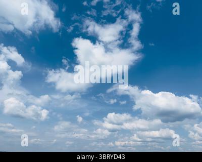 Wunderschöner, hellblauer Himmel mit weichen, weißen Wolken an einem sonnigen Tag. Stockfoto