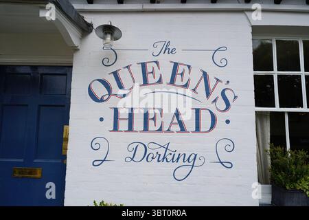 Fassade eines traditionellen englischen Pubs mit blauer Tür und sorgfältig platzierten Pflanzen. Dorking, England Stockfoto