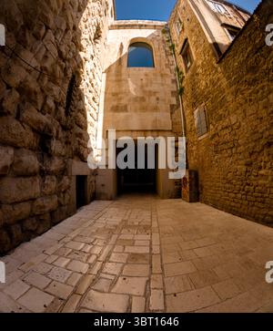 Split, Kroatien - 8. September 2023: Eine schmale Steinstraße führt durch einen Bogengang in den Diokletianpalast, der zum UNESCO-Weltkulturerbe gehört Stockfoto