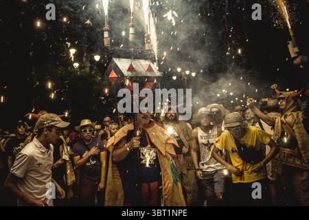 14. September 2019, Sitges, Katalonien, Spanien: Die Zuschauermenge beschützt sich mit Hüten und Gläsern, während sie unter den fliegenden Funken des „Correfocs“-Feuerwerks tanzen, während das Santa Tecla Festival von Sitges stattfindet. (Foto: © Matthias Oesterle/ZUMA Wire) Stockfoto