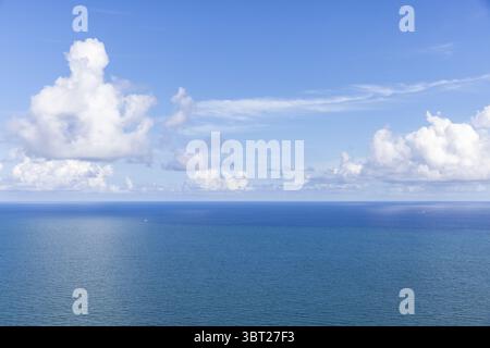 Aus der Vogelperspektive auf eine riesige Weite des tiefblauen Ozeans, die unter einem Himmel voller flauschiger weißer Wolken den Horizont trifft, Miami Beach, Florida, USA. Stockfoto