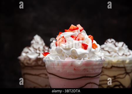 Milchshakes mit verschiedenen Geschmacksrichtungen auf dunklem Hintergrund. Stockfoto