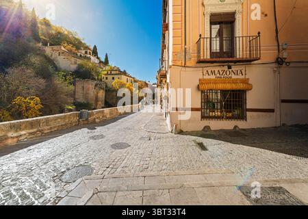 Fußgänger laufen entlang des Darro-Flusses auf der engen, historischen Carerra del Darro Straße in der Altstadt von Granada, Spanien, Andalusien. Stockfoto