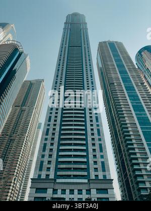 Vertikales Stockbild der Skyline von zeitgenössischem Dubai mit hoch aufragenden Gebäuden von Straßenniveau Stockfoto