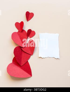 Leeres Papier mit rotem Herzen Hintergrund, ästhetische flache Lay mit leerem Papier, pastellfarbene Hintergrundtapete Stockfoto