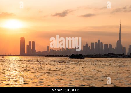 Blick auf die Skyline der Stadt bei Sonnenuntergang von einer Yacht, Dubai Downtown Skyline bei Sonnenuntergang Stockfoto