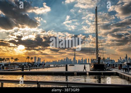 Dramatischer Sonnenuntergang am Hafen von Dubai Creek mit Booten und Yachten Stockfoto