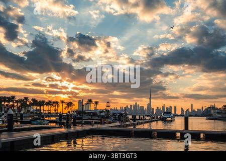 Atemberaubender Sonnenuntergang über dem Yachthafen mit City Skyline, Booten und Palmen I ruhigen Blick aufs Wasser, HD Hintergrund - 4K Wallpaper Stockfoto