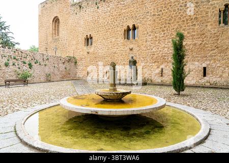 Ein ruhiger Innenhof mit einem runden Brunnen umgeben von historischen Steinmauern in Brihuega, der die reiche Architektur und die ruhige Atmosphäre zeigt Stockfoto