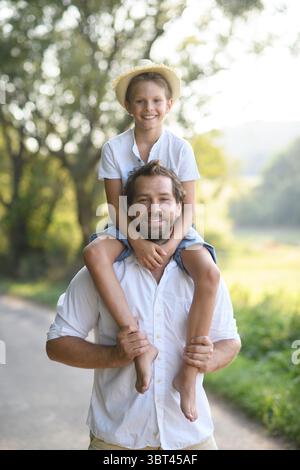 Glücklicher Vater, der den Sohn auf den Schultern trägt. Stockfoto