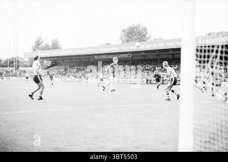Fußball: Haarlem - Sparta Football Haarlem, Whizgle News, Dutch Desk, Niederlande, 1950 - 2000 am 15-08-1981. Diese Themen sind in der Abbildung dargestellt. Die Szene fängt einen dynamischen Moment in einem Fußballspiel in einem pulsierenden Stadion voller Zuschauer ein. Die Spieler werden in der Mitte der Action dargestellt, wobei eine Person deutlich springt, um einen Schuss auf das Tor zu versuchen, was ein Gefühl von Dringlichkeit und Spannung vermittelt. Die Athleten tragen kontrastierende Mannschaftsuniformen – eine in dunkleren Farben und die andere in helleren Tönen – und sorgen für ein visuelles Interesse und betonen die Wettbewerbscharakter des Spiels. Der Ausdruck Stockfoto