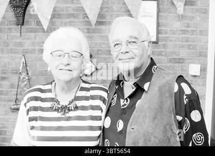 Verheiratet seit 50 Jahren Mertens Haarlem, Niederlande, Whizgle News, Dutch Desk, Niederlande, 1950 - 2000 am 02-09-1996. Das Bild enthält diese Themen. Die Szene zeigt ein älteres Ehepaar, das eng zusammensteht und Wärme und Vertrautheit ausstrahlt. Die Frau hat einen Kopf aus kurzen, weißen Haaren, die ordentlich gestylt sind, und sie trägt ein gestreiftes Hemd mit einem Muster von waagerechten Linien. Zu ihren Accessoires gehört eine auffällige Halskette, die einen Hauch von Eleganz verleiht. Neben ihr trägt der Mann eine Brille und hat graue Haare, einfach gestylt. Er trägt ein farbenfrohes Hemd, das mit verschiedenen kreisförmigen Mustern verziert ist. Stockfoto