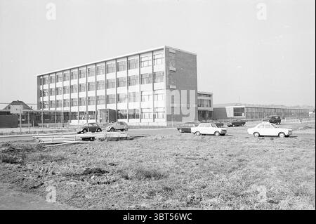 LTS St. Paul Hillegom, Whizgle News, Dutch Desk, Niederlande, 1950 - 2000 am 03-1969. Diese Themen sind in der Abbildung dargestellt. In dieser Szene zeigt ein weites Bild ein modernes mehrstöckiges Gebäude, das hauptsächlich aus Beton und Glas besteht und ein boxförmiges architektonisches Design aufweist. Das Gebäude verfügt über mehrere horizontale Streifen mit weißem Rahmen, die sich vom dunkleren Backsteinsockel abheben. Die Fassade wird von großen Fenstern dominiert, die einen Blick auf das Innere erlauben. Neben diesem Gebäude ist ein niedrigeres, einstöckiges Gebäude zu sehen, das möglicherweise als nebengebäude oder zusätzliche Einrichtung dient, mit Simple Stockfoto