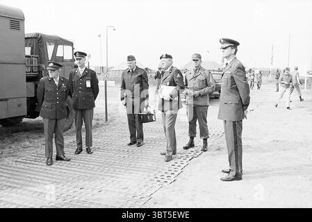 Amerikanische Soldaten in der Nähe von Amsterdam Soldiers, Whizgle News, Dutch Desk, Niederlande, 1950 - 2000 am 01-09-1977. Dies sind die Elemente im Bild. Die Szene spielt im Freien, wahrscheinlich in einem militärischen oder formellen Kontext. Die Einzelpersonen werden auf einem Ebenen, offenen Gelände gesammelt, das durch eine strukturierte Oberfläche gekennzeichnet ist, die möglicherweise aus Matten oder Platten besteht, die einen festen Boden bieten. Im Vordergrund steht eine Gruppe von Männern in einem Halbkreis, die in Militäruniformen gekleidet sind, die in Farbe und Stil variieren, was auf eine Reihe von Rängen und Rollen hindeutet. Die Uniformen umfassen dunkles Marineblau und verschiedene Insignien Stockfoto