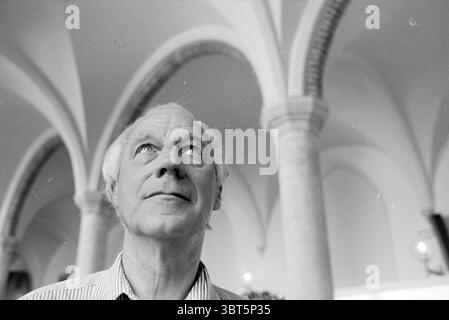 Künstler mr. Grabijn Rathaus Refektorium, Whizgle News, Dutch Desk, Niederlande, 1950 - 2000 am 03-08-1995. Die Abbildung zeigt diese Themen. Die Szene zeigt einen älteren Mann mit silbernen Haaren, der mit einem kontemplativen Ausdruck nach oben blickt. Sein Gesicht wird sanft beleuchtet und hebt die Linien und den Charakter hervor, die mit dem Alter einhergehen. Die Umgebung um ihn herum ist prächtig, geprägt von hohen, bogenförmigen Säulen, die ein Gefühl von Tiefe und Raum schaffen. Die Bögen ragen elegant zu einer gewölbten Decke, wo das Zusammenspiel von Licht und Schatten Dimension verleiht. Die Farbpalette neigt sich in Richtung Graustufen und betont den Stockfoto