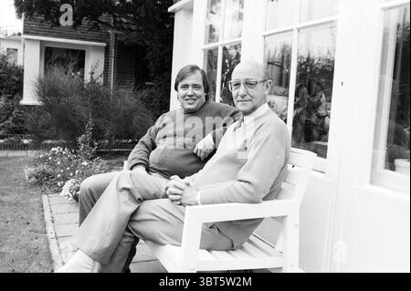 Van de Water Jr. und Sr. Europaparlamentarier und früherer Rat Politik, Volkspolitik, Whizgle News, Dutch Desk, Niederlande, 1950-2000, 28-10-1989. Die Abbildung zeigt diese Themen. In einer ruhigen Umgebung im Freien sitzen zwei Personen bequem auf einer weißen Holzbank neben einem hellen, sonnendurchfluteten Fenster. Im Hintergrund befindet sich ein charmantes Haus mit viel Grün, das eine ruhige Atmosphäre schafft. Beide Figuren strahlen ein Gefühl von Leichtigkeit und Kameradschaft aus. Die Person auf der linken Seite trägt einen gemütlichen, dunklen Pullover und eine leichte Hose, die leicht zum anderen neigt. Er hat eine entspannte Haltung Stockfoto