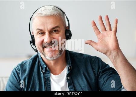 Lächelnder, leitender Mann mit Videoanruf und Headset Stockfoto