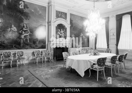 Int. House Duin en Kruidberg Interior, Whizgle News, Dutch Desk, Niederlande, 1950 - 2000 am 02-11-1982. Die Abbildung zeigt diese Themen. In einem elegant eingerichteten Raum steht ein großer, runder Esstisch im Mittelpunkt der Bühne, der mit einer weißen Tischdecke bedeckt ist, die sich zu dem polierten Holzboden hineinzieht. Um den Tisch herum befinden sich mehrere zierliche, gepolsterte Stühle, von denen jeder mit komplizierten Blumenmustern verziert ist, die die Pracht des Raumes widerspiegeln. Die Wände sind mit weitläufigen, klassischen Wandgemälden geschmückt, die ruhige Pastoralszenen zeigen, mit Figuren in historischer Kleidung und üppigen Landschaften, die wie zu sein scheinen Stockfoto