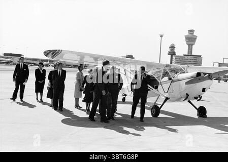 Eröffnung der Verlängerung des Pier B bei Schiphol durch Prinz Bernhard. Er kommt mit einem Stinson-Flugzeug an. Schiphol, Whizgle News, Dutch Desk, Niederlande, 1950 - 2000 am 03-05-1990. Dies sind die Themen im Bild. Die Szene spielt an einem Flughafen und hält einen Moment der Ankunft oder Abreise fest. Im Vordergrund ist ein kleines Leichtflugzeug gelandet, dessen glänzende, polierte Oberfläche helles Sonnenlicht reflektiert. Der weiße Korpus des Flugzeugs ist mit einigen bunten Streifen verziert, die an einen Vintage-Stil der Luftfahrt erinnern. Um das Flugzeug herum versammelt sich eine Gruppe elegant gekleideter Individuen. Männer in dunklem Su Stockfoto