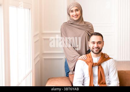 Fröhliche Junge Muslimische Familie Paar Posiert Zu Hause Stockfoto