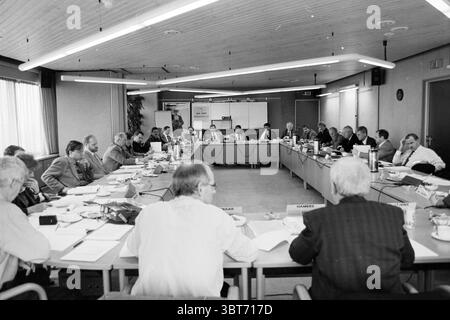 VNU Betriebsratstreffen Haarlem, Niederlande, Whizgle News, Dutch Desk, Niederlande, 1950 - 2000 am 21. 01. 1996. Dies sind die Themen im Bild. Die Szene spielt in einem geräumigen, gut beleuchteten Konferenzraum, der durch einen großen rechteckigen Tisch mit mehreren Personen gekennzeichnet ist. Die vorherrschenden Farben sind neutrale Töne – Grautöne, Weißtöne und die warmen Farbtöne von Holzelementen. Verschiedene Personen diskutieren, einige hören aufmerksam zu, während andere lebhaft sprechen. Sie scheinen alle in formeller Kleidung zu sein, was auf eine Berufs- oder Unternehmensumgebung hindeutet Stockfoto