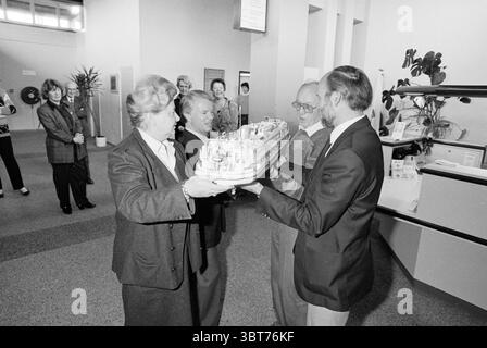 Übergabe des Henry Dunant Roten Kreuzes an Burg. Schmitz [Schiff] Rotes Kreuz Krankenhaus, Whizgle News, Dutch Desk, Niederlande, 1950 - 2000 am 07-03-1990. Dies sind die Themen im Bild. Die Szene fängt einen Moment in einem Innenbereich ein, wahrscheinlich ein formelles Ereignis oder eine Präsentation. Eine Gruppe von Einzelpersonen versammelt sich um eine zentrale Anzeige. Vier Personen sind an vorderster Front stark engagiert, zwei auf jeder Seite. Die Individuen im Vordergrund halten ein detailliertes Modell eines Schiffes, das die Begeisterung und Bedeutung dieses Austauschs anzeigt. Die Personen, die das Modell erhalten, AR Stockfoto