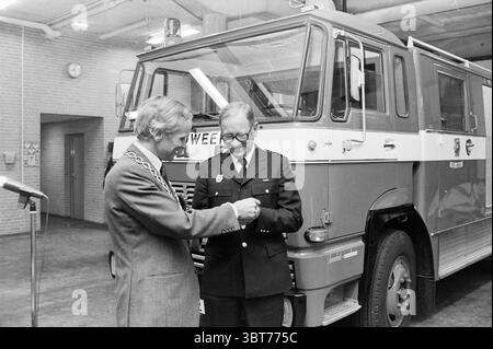 Übergabe des neuen Feuerwehrfahrzeugs H'stede Fire Brigade Übergabe und Transfer Heemstede Van den Eijndekade the Netherlands, Whizgle News, Dutch Desk, Niederlande, 1950 - 2000 am 07-09-1978. Diese Themen werden in der Abbildung angezeigt. In einem geräumigen Raum mit poliertem Betonboden steht ein markanter Feuerwehrwagen vor einer strukturierten Ziegelwand. Der Lkw, der in einer auffälligen Kombination aus Rot und weiß lackiert ist, steht als Mittelpunkt und zeigt sein robustes Design und seine Funktionalität. Im Vordergrund stehen zwei Männer im Gespräch. Ein Mann, geschmückt mit einer zeremoniellen Kette um seine ne Stockfoto