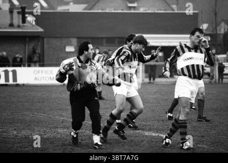 Fußball: RCH - DHC Heemstede the Netherlands, Whizgle News, Dutch Desk, Niederlande, 1950 - 2000 am 01-02-1992. Diese Themen sind in der Abbildung dargestellt. Die Szene fängt einen dynamischen Moment in einer Sportwelt ein, wahrscheinlich ein Fußballspiel. Die Spieler sind in gestreiften Trikots mit Kontrastfarben gekleidet und haben verschiedene Posen, die auf Action und Dringlichkeit hinweisen. Der Torhüter ist in einer grauen Uniform besonders sichtbar, mit intensiven Gesten, möglicherweise mit Teamkollegen oder mit dem Spiel zu kommunizieren. Die anderen Spieler werden in der Mitte der Action gesehen, wobei einer anscheinend o feiert Stockfoto