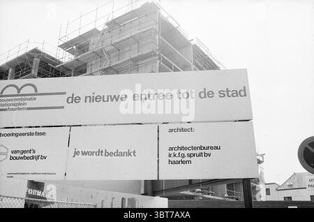 Schild Downtown 'Thank you' Schilder, Whizgle News, Dutch Desk, Niederlande, 1950 - 2000 am 27-05-1974. Diese Themen sind in der Abbildung dargestellt. Die Szene zeigt eine städtische Baustelle unter einem grauen, bewölkten Himmel, die ein gedämpftes Licht über das Gebiet wirft. Im Vordergrund steht ein großes, leeres Schild mit stark weißen Tafeln, die sich im Kontrast zur Umgebung befinden. Die Tafeln sind schlicht verziert und vermitteln ein Gefühl der Vorfreude auf zukünftige Entwicklungen. Im Hintergrund zeichnet sich ein teilweise fertiggestelltes Gebäude ab, dessen Skelettstruktur sowohl auf Potential als auch auf Störungen hindeutet. Metallgerüst Stockfoto