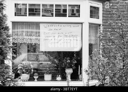 Ausschilderung Marsstraat Borden Haarlem Marsstraat Niederlande, Whizgle News, Dutch Desk, Niederlande, 1950 - 2000 auf 30-05-1988. Das Bild enthält diese Themen. Die Szene präsentiert ein gemütliches, einheimisches Ambiente, das durch ein Fenster betrachtet wird. Das Fenster selbst hat ein klassisches, mehrschichtiges Design, in weiß gerahmt, das sich von einer Ziegelwand abhebt, die eine warme und rustikale Atmosphäre verleiht. Die Glasscheiben sind klar und erlauben einen Blick in den Innenraum. Im Inneren sind verschiedene dekorative Objekte auf einer Fensterbank zu sehen. Dazu gehören Topfpflanzen, vielleicht ein paar bunte Blumen und einige Keramikfiguren Stockfoto