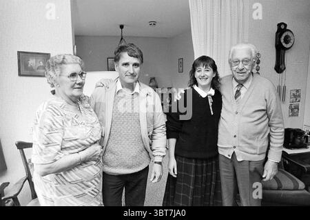 Cremers Paar heiratete 60 Jahre Paare, Whizgle News, Dutch Desk, Niederlande, 1950 - 2000 am 20-11-1987. Das Bild enthält diese Themen. Die Szene fängt ein warmes und einladendes Ambiente in Innenräumen ein. Im Vordergrund stehen vier Personen eng zusammen und zeigen ein Gefühl von Einheit und familiärer Verbundenheit. Auf der linken Seite trägt eine ältere Frau ein gemustertes Kleid mit weichen Farbtönen, das ihr silbernes Haar mit lockeren Locken ergänzt. Sie hält ihre Hände an der Taille zusammen und strahlt ein Gefühl von Stolz und Wärme aus. Neben ihr steht ein Mann mittleren Alters zuversichtlich und trägt eine helle Farbe Stockfoto