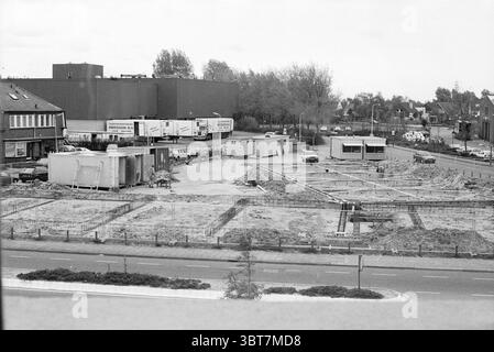 Bauen Sie Wohnungen in Bloemendaal Bloemendaal, Whizgle News, Dutch Desk, Niederlande, 1950 - 2000 am 14-05-1991. Die Abbildung zeigt diese Themen. Die Szene zeigt eine Baustelle, die sich in der frühen Entwicklungsphase befindet. Der Boden ist größtenteils unfruchtbar, überall verstreut sind Schutt- und Schutthaufen. Es werden Rahmenkonstruktionen, möglicherweise für ein Fundament, eingerichtet, die zeigen, wo Gebäude schließlich Gestalt annehmen werden. Im Vordergrund verläuft parallel zum Gelände eine gepflasterte Straße, die von einem kleinen Grünstreifen aus niedrigen Sträuchern und einigen Grasflecken begrenzt wird. Zwei Disti Stockfoto