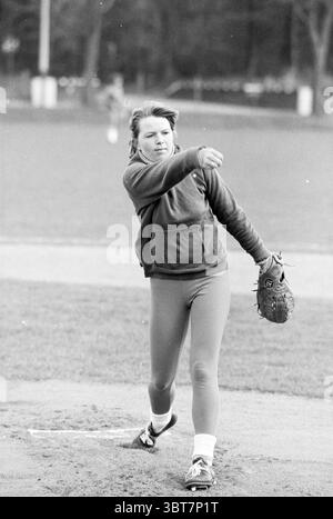 Softball-Anschluss. DSC 74 Männer Kennemerland Männer Bloemendaal Frauen Softball, Whizgle News, Dutch Desk, Niederlande, 1950 - 2000 auf 19-04-1980. Dies sind die Themen im Bild. Die Szene fängt einen dynamischen Moment in einer Outdoor-Sportwelt ein, insbesondere in einem Baseball- oder Softballfeld. Ein junger Athlet, gepaart und konzentriert, befindet sich im Mittelkampf und zeigt Leichtathletik und Konzentration. Sie trägt einen dunklen Hoodie und helle Leggings mit scharfen Kontrasten. Ihre Bewegung überträgt Energie, wobei ihr Arm zurückstreckt, um den Ball freizugeben, was auf einen Wettkampfgeist hindeutet. Der Hintergrund zeigt einen Spaciou Stockfoto