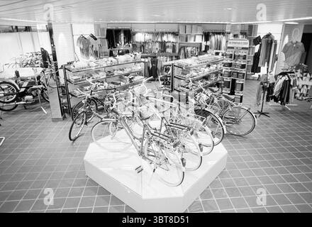 Int. Neuer Fahrradladen Verdonschot Radwege Radfahrer Heemstede Niederlande, Whizgle News, Dutch Desk, Niederlande, 1950 - 2000 am 27-02-1989. Das Bild enthält diese Themen. Die Szene zeigt ein geräumiges Interieur im Einzelhandel, das sich durch eine Mischung aus Fahrraddisplays und Kleiderständern auszeichnet. Im Vordergrund befinden sich mehrere Fahrräder auf einem weißen Sockel. Die Rahmen zeigen eine Reihe gedämpfter Pastelltöne, darunter sanfte Blau-, Grün- und Gelbtöne, während Chrom- und Schwarzakzente Kontraste bilden. Um die Fahrräder herum gibt es eine Ausstellung von Kleidung, einschließlich Hemden, Wagenheber Stockfoto
