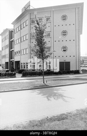 Unisource Building Hoofddorp [Polarisavenue 97] Hoofddorp the Netherlands, Whizgle News, Dutch Desk, Niederlande, 1950 - 2000 am 03-06-1997. Dies sind die Elemente im Bild. Die Szene verfügt über ein modernes, mehrstöckiges Gebäude, das sich durch seinen unverwechselbaren architektonischen Stil auszeichnet. Die Fassade zeigt ein Muster aus hellen Ziegeln, durchsetzt mit dunklen kreisförmigen Elementen auf der Außenseite. Große Fenster unterstreichen die Struktur und deuten auf die funktionale Eleganz des Designs hin, während sie einen Einblick in die Inneneinrichtung gewähren. An der Vorderseite steht ein schlanker Baum allein auf einem gepflegten Gras Stockfoto